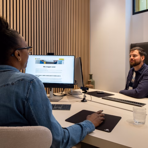 Vrouw wordt geinterviewd in het Happy Labs UX Research lab
