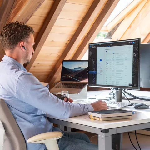 Designer Joshua is bezig met een design terwijl hij zit aan zijn bureau.